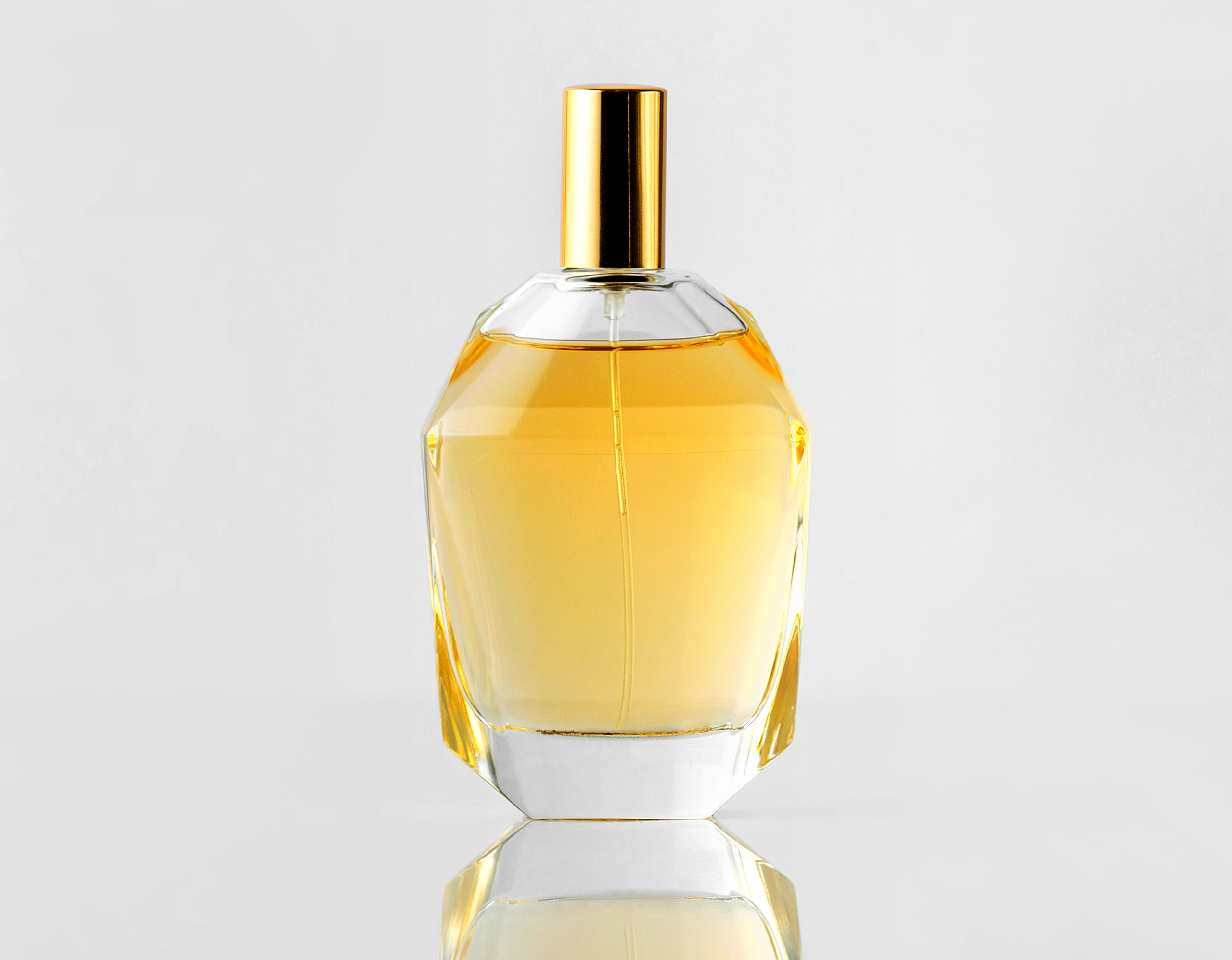 front-view-yellow-fragrance-bottle-with-golden-cap-white-wall (1)